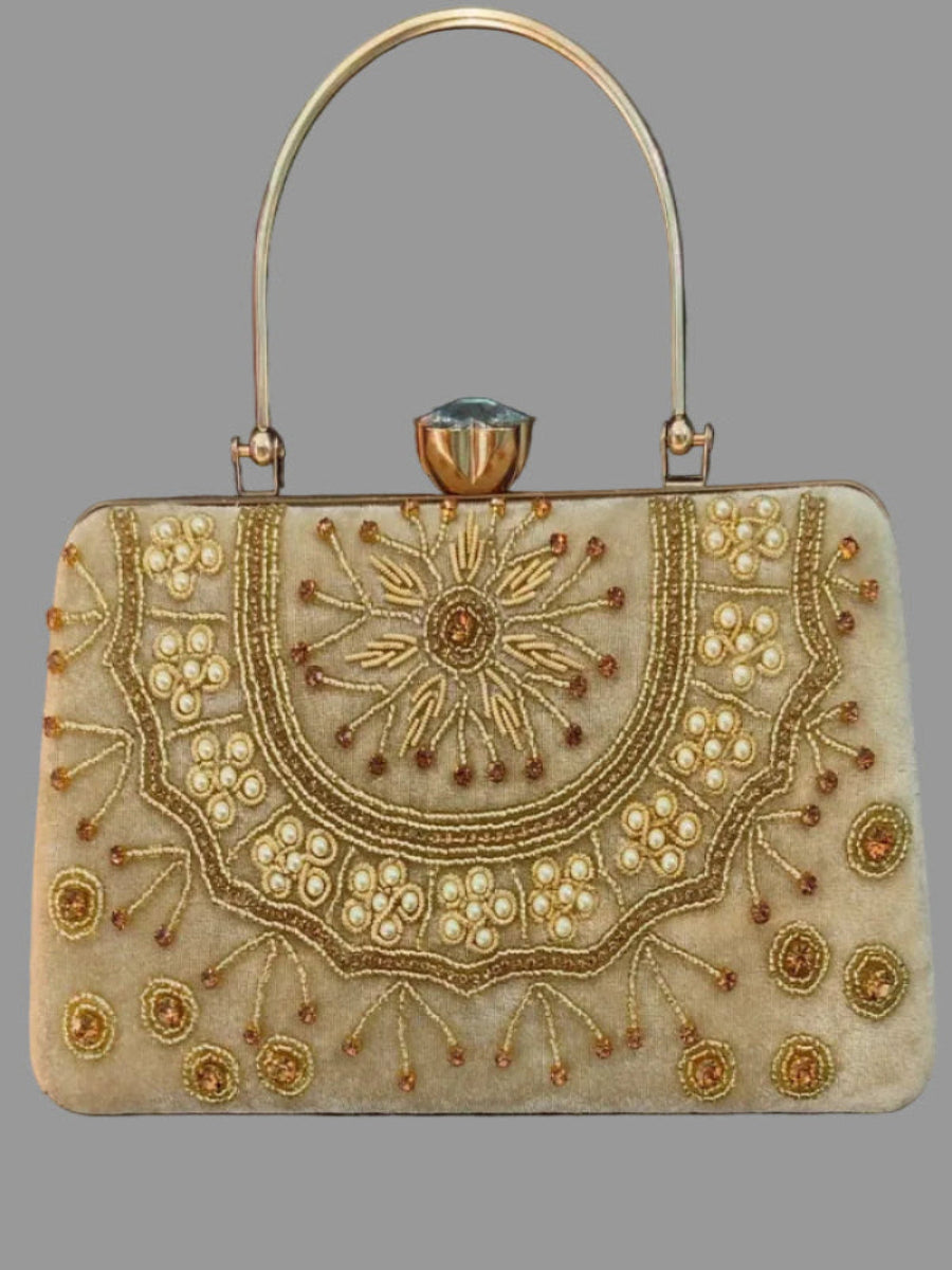 Decorative handbag with intricate gold embroidery on a gray background