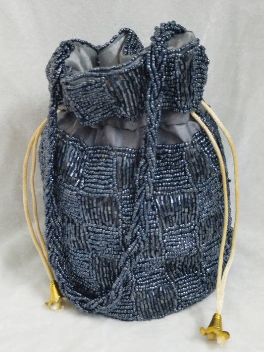Gray Beaded drawstring bag with gold accents on a light gray background