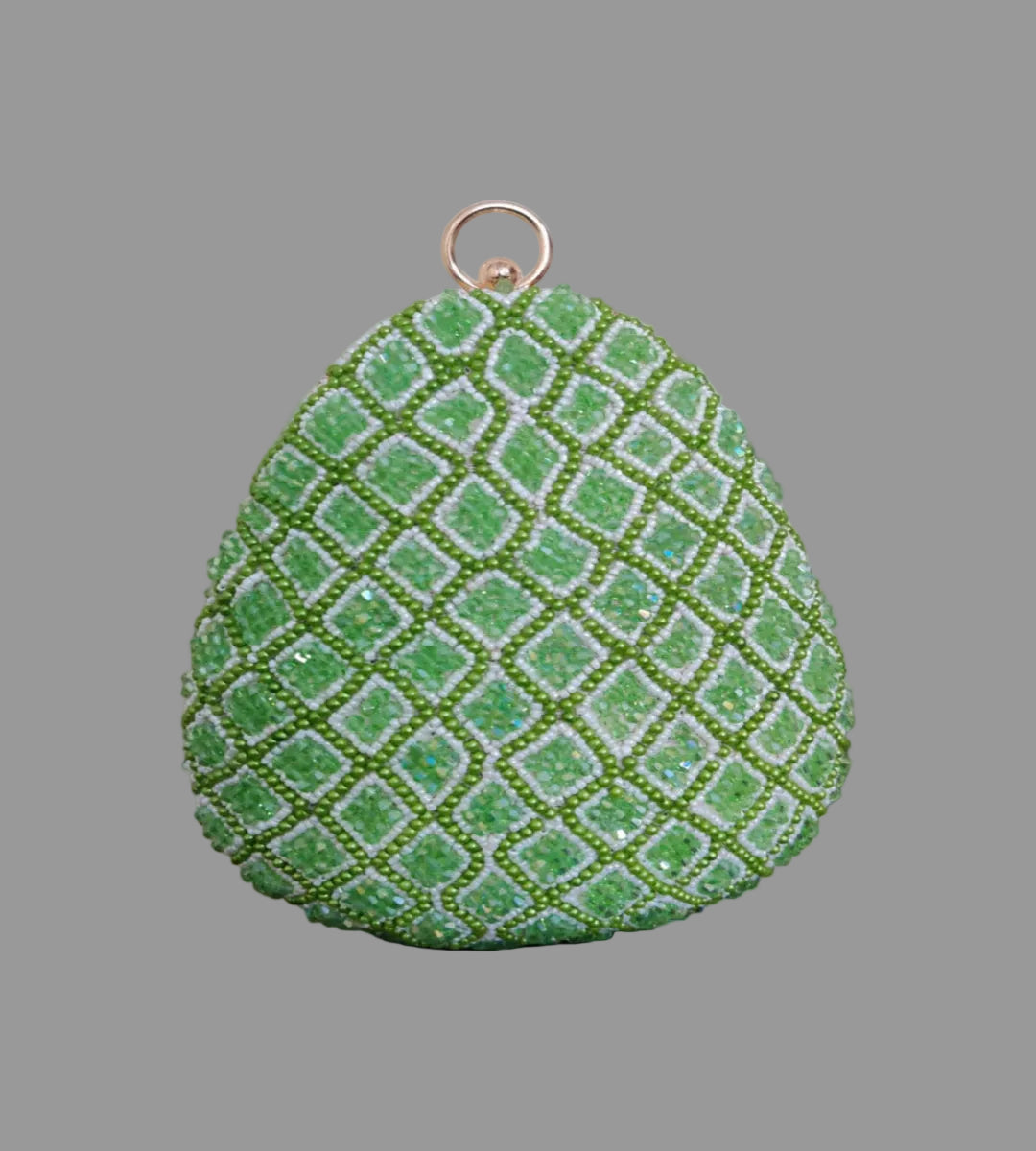 Green textured teardrop-shaped object on a wooden surface with a blurred indoor background