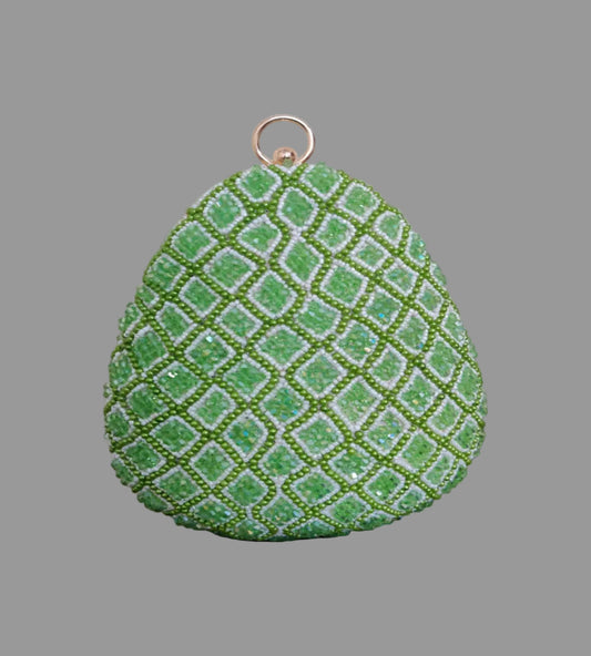 Green textured teardrop-shaped object on a wooden surface with a blurred indoor background