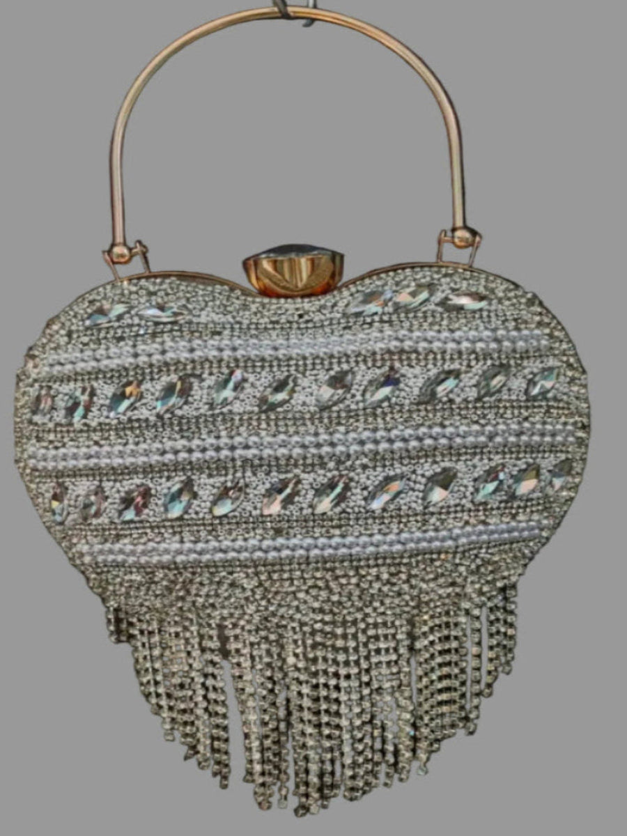 Heart-shaped handbag with beaded details and a handle on a gray background