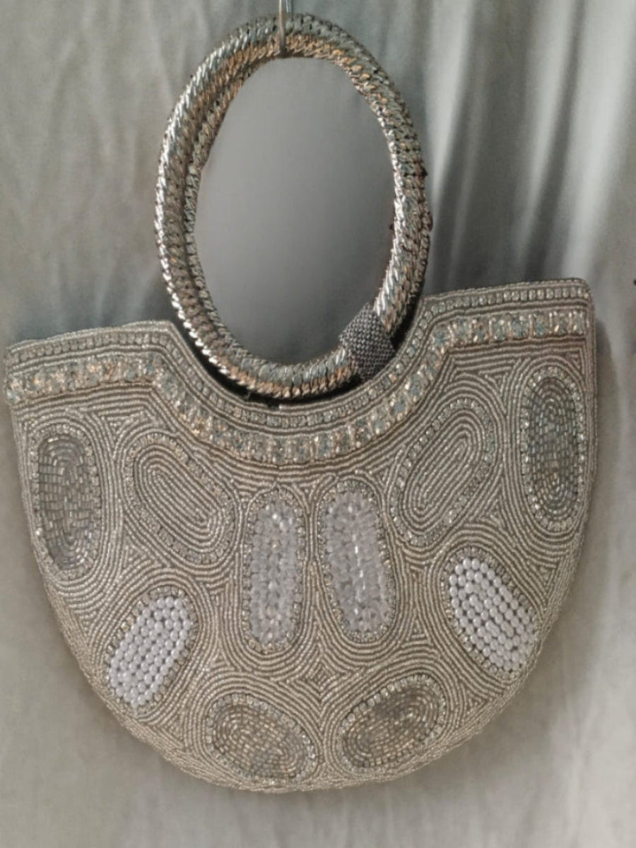 Silver beaded handbag with intricate patterns .