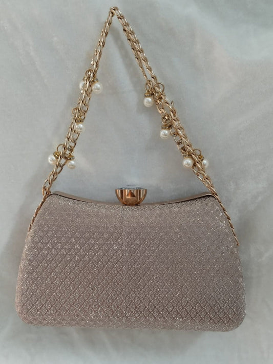 Sparkly handbag with a chain strap on a light gray background
