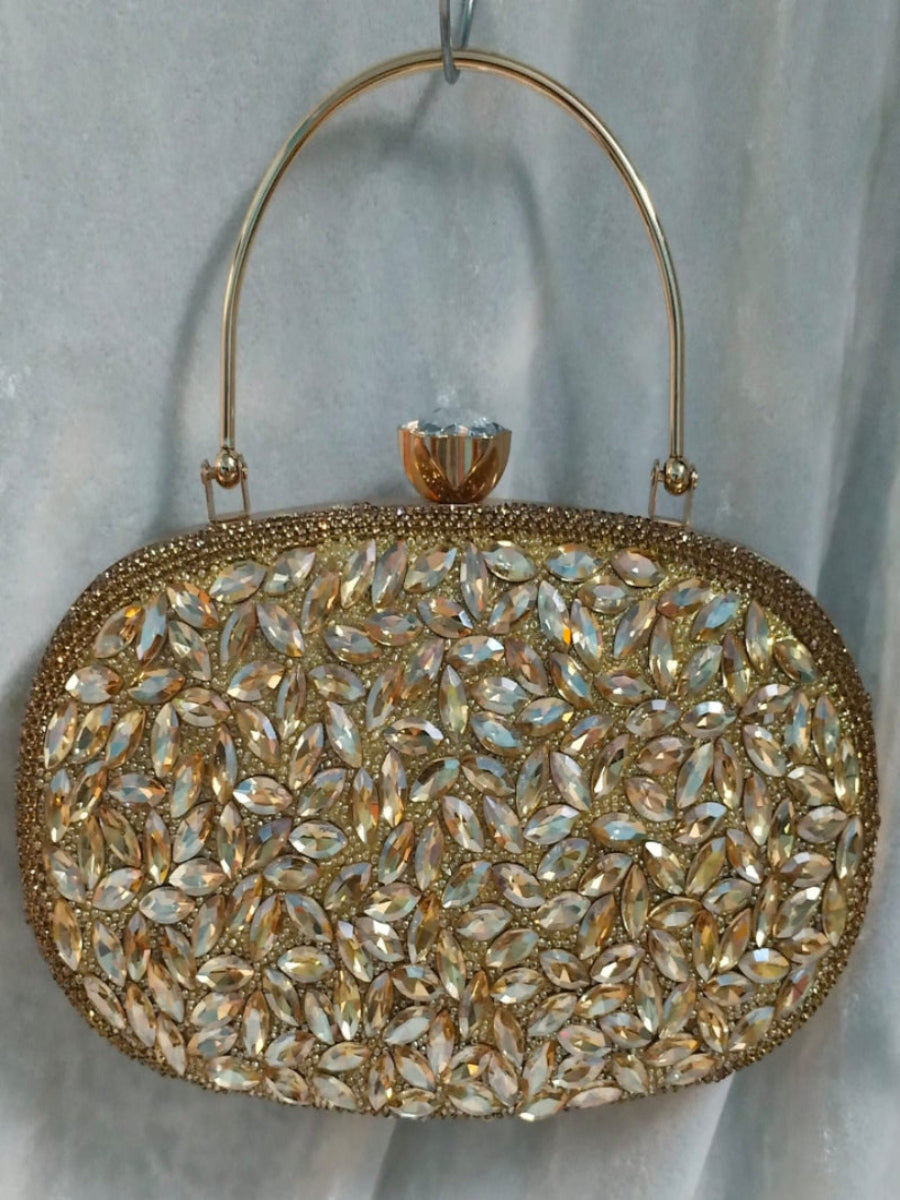 Gold clutch bag with crystal embellishments on a light gray background