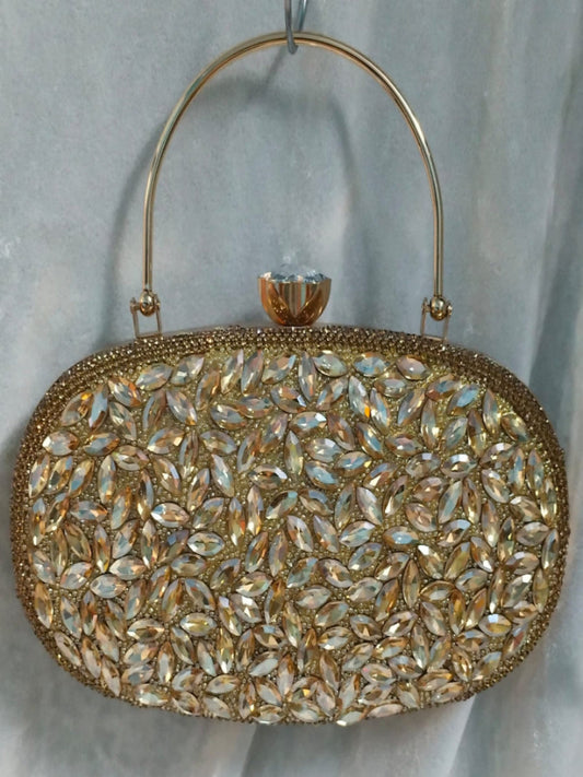 Gold clutch bag with crystal embellishments on a light gray background