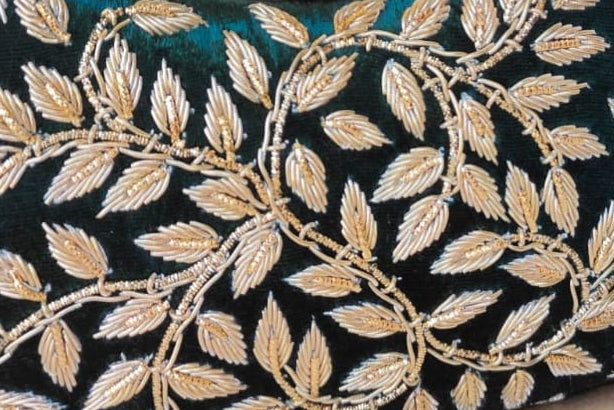 Decorative handbag with leaf patterns on a wooden surface with a soft background