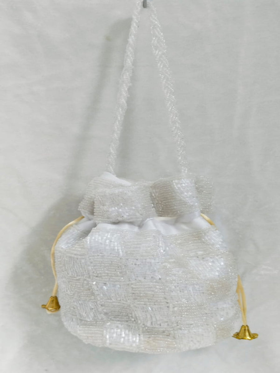 Textured handbag with gold accents on a light gray background