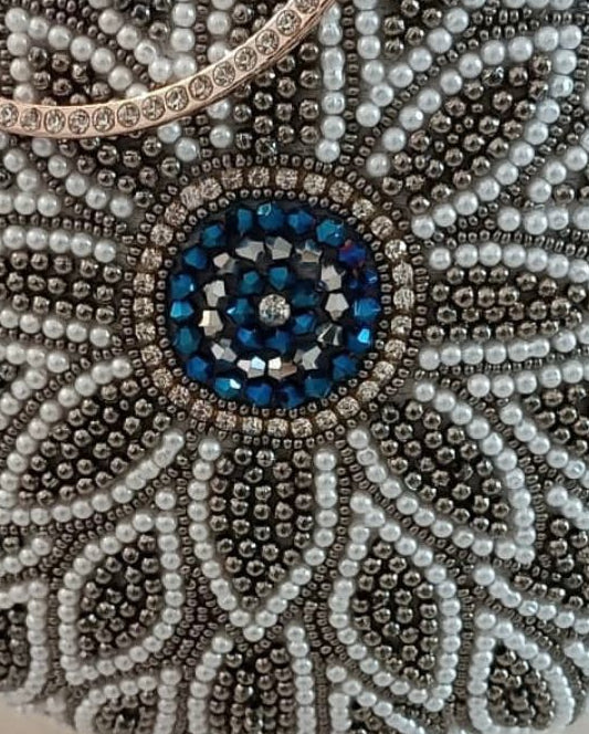 Beaded handbag with floral design and blue center on a light background