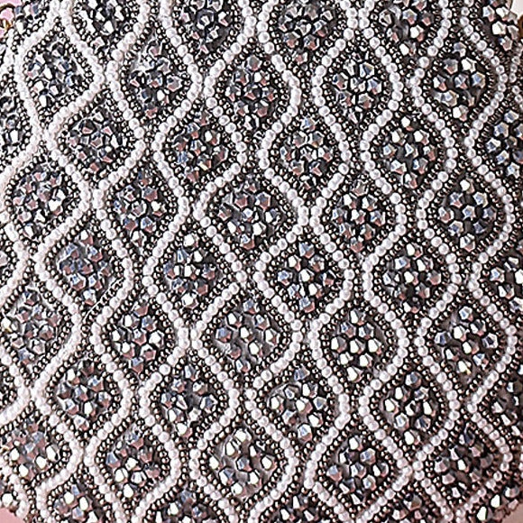 Decorative handbag with intricate pattern on a pink surface