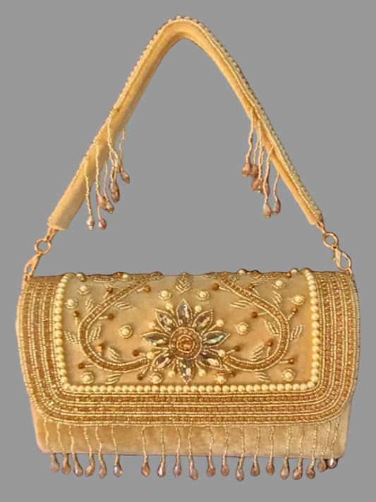 Gold embroidered handbag with fringe details on a gray background