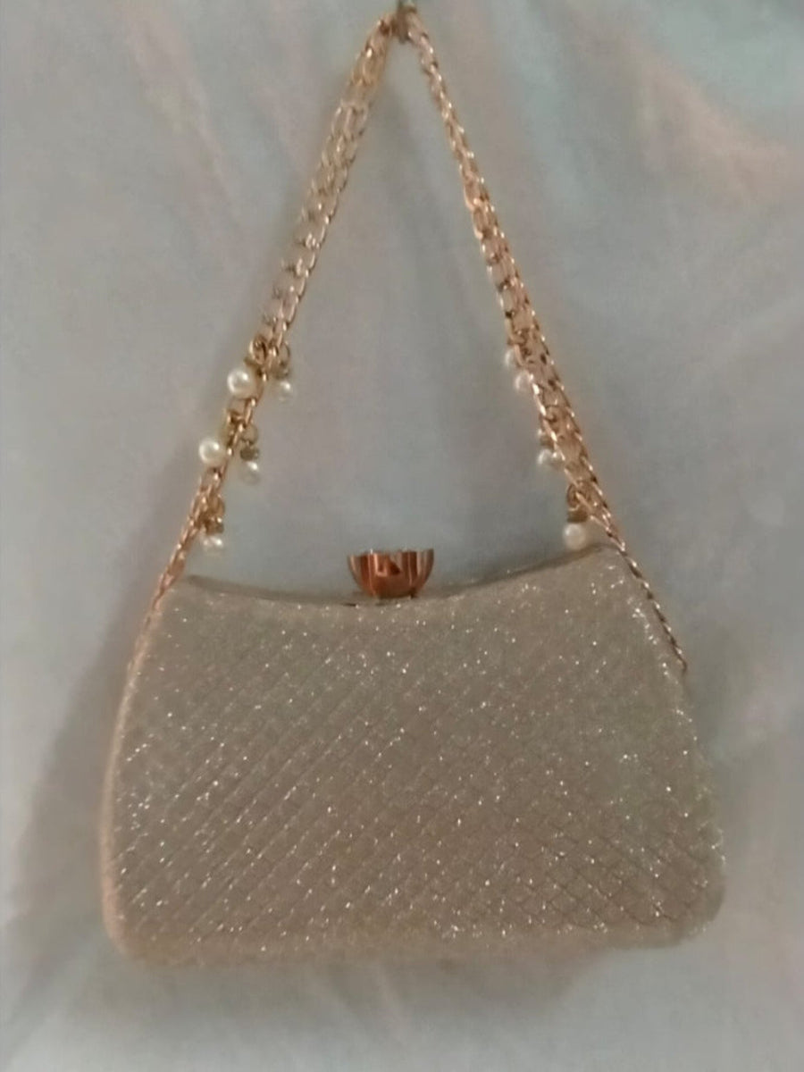 Gold handbag with chain strap on a light background