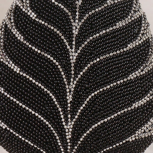 Black beaded handbag with leaf design on a white background