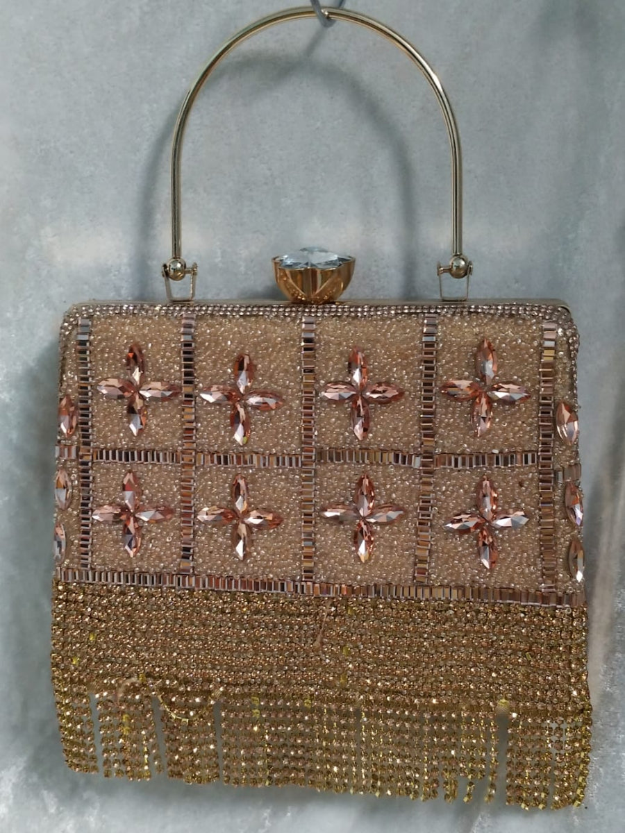 Gold beaded handbag with floral patterns on a gray background