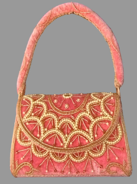 Pink handbag with gold embroidery on a gray background