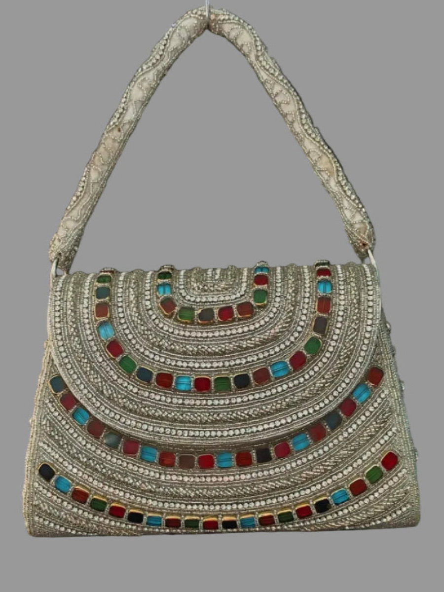 Decorative handbag with colorful gemstones on a gray background